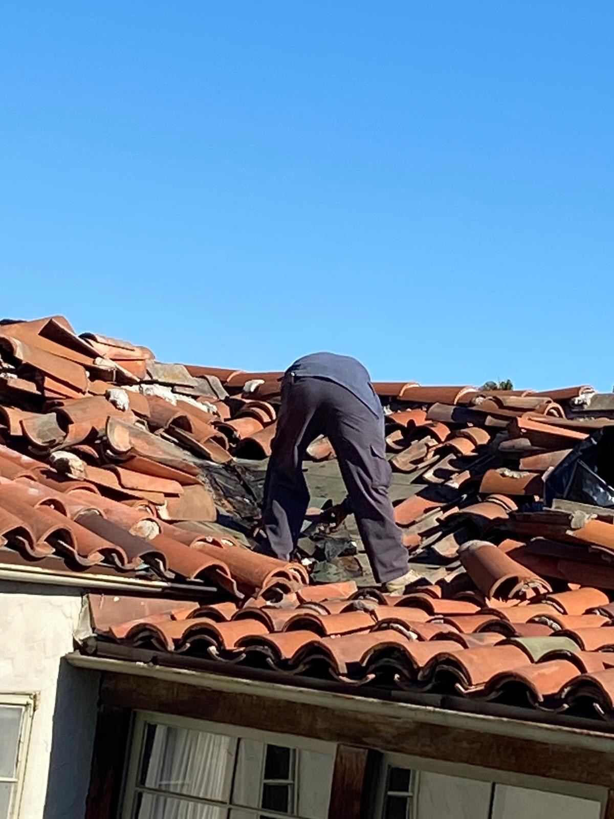 Crew lifting clay tiles for a re-lay